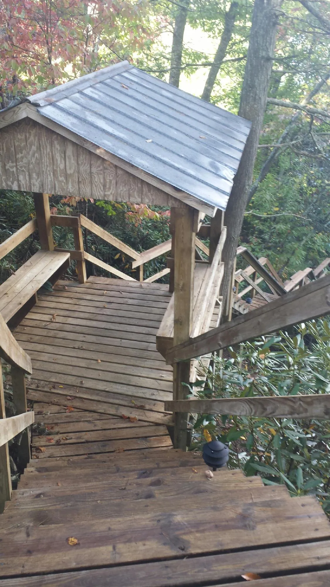 Metal roofed shelter over wooden steps on a wooded walkway — Skylight Repair & Installation work by our crew in Wharton