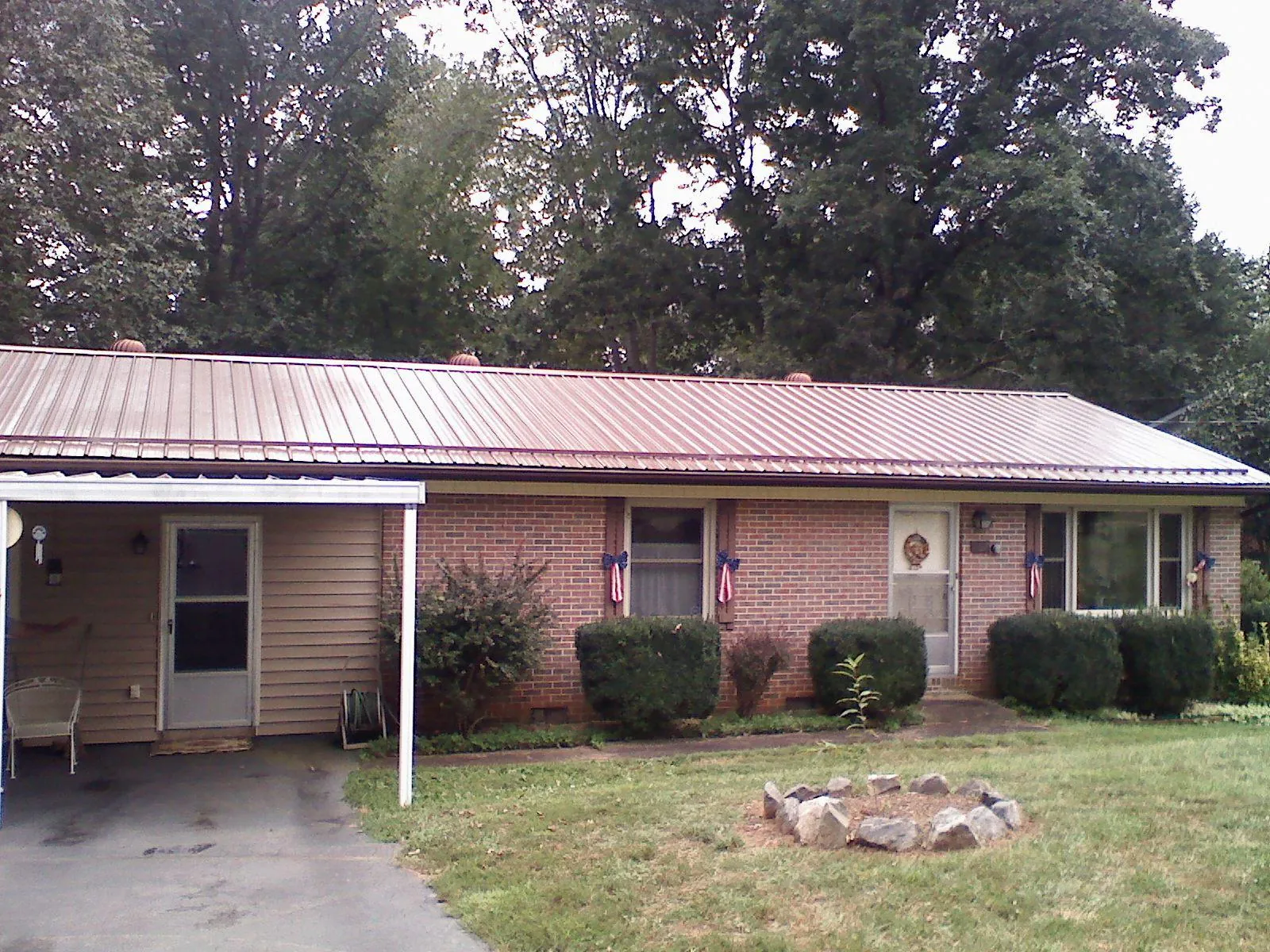 Bronze metal roof and carport on a brick ranch home — Roof Repair work by our crew in Wharton